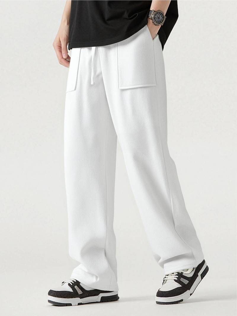 Person wearing white pants with a black shirt on a light gray background