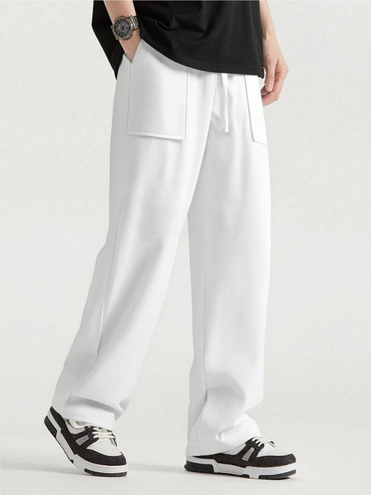 Person wearing white pants with a black shirt on a light gray background