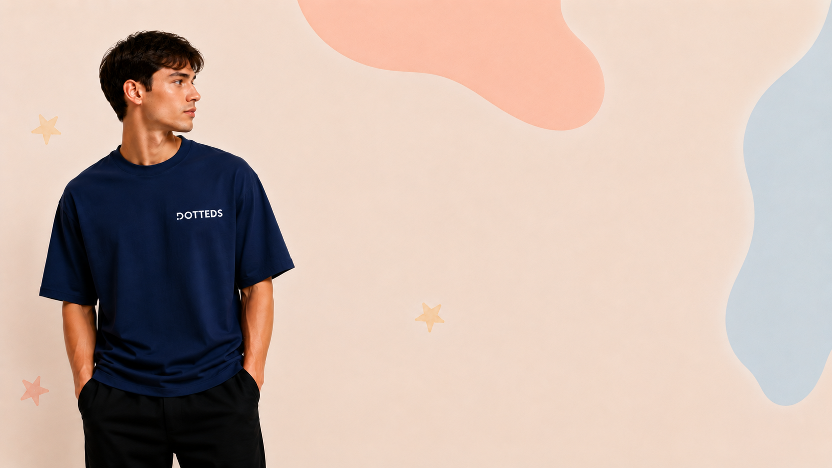 Man wearing a navy blue t-shirt with 'DOTTED' logo against a pastel abstract background